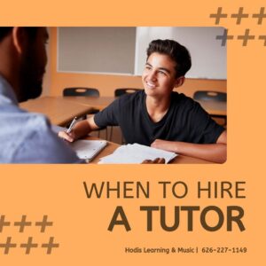 A boy smiles as he talks to his tutor